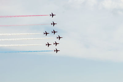 Low angle view of airshow against sky