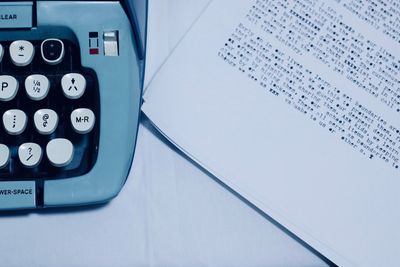 High angle view of typewriter with papers on table