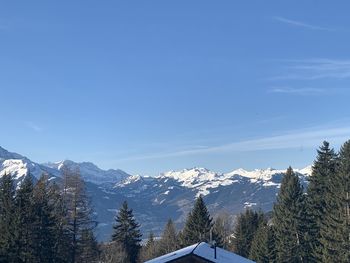 Scenic view of snowcapped mountains against blue sky