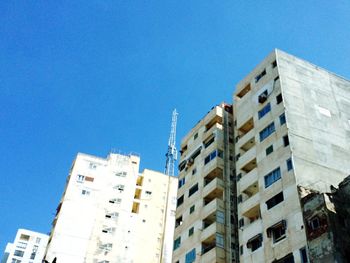 Low angle view of buildings against clear blue sky