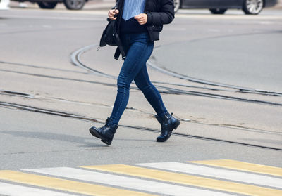 Low section of man walking on road