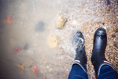 Low section of man standing in water