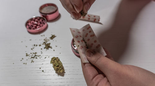 Cropped image of woman making joint on table