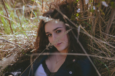 Portrait of beautiful young woman lying on land