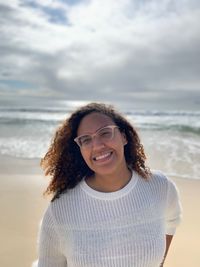 Portrait of smiling woman standing at beach