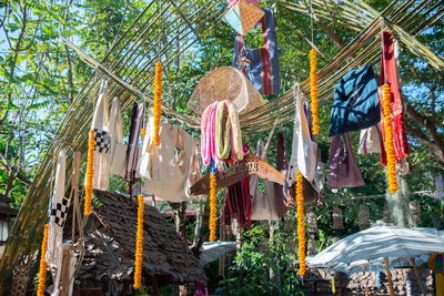 Low angle view of decorations hanging by trees outside building