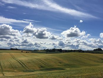 Scenic view of field against cloudy sky