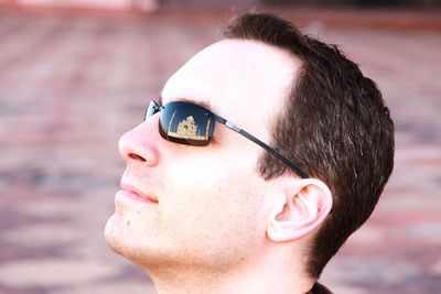 Man with reflection of taj mahal on sunglasses