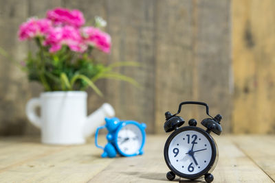 Close-up of clock on table against wall