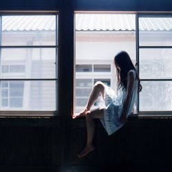 Woman sitting in glass window