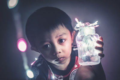 Close-up of boy holding jar of fairy lights