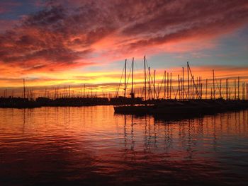 Sailboats in sea at sunset