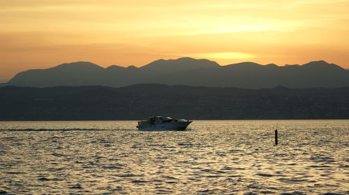 Scenic view of sea against mountains during sunset