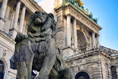 Low angle view of statue against building in city