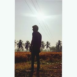 Man standing on field against sky