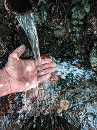 High angle view of human hand on rock