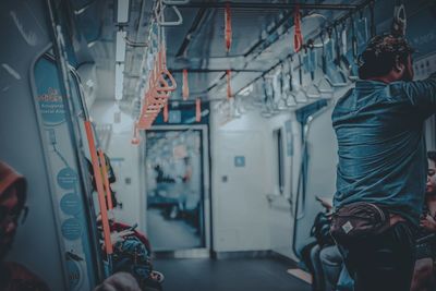 Rear view of man standing in train