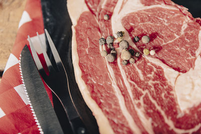 Raw dry aged wagyu tomahawk steak as close-up on black board.