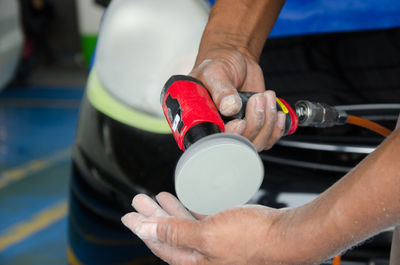 Midsection of man cleaning car at garage