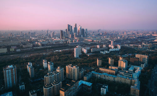 Aerial view of buildings in city against sky during sunset