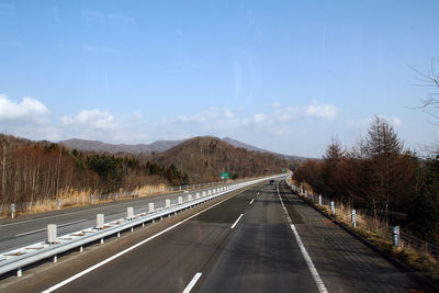 Road leading towards mountain against sky