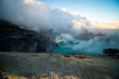 Smoke emitting from volcanic mountain against sky