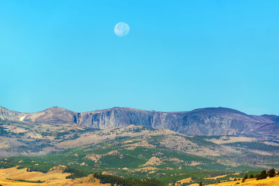 Low angle view of full moon against clear blue sky