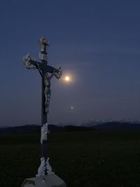 Cross on field against sky