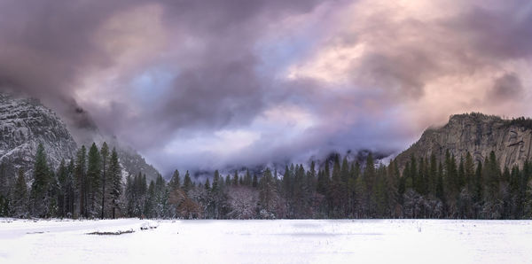 Scenic view of snowcapped landscape and mountains against cloudy sky