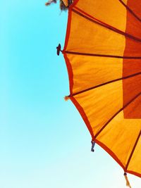 Directly below shot of yellow umbrella against clear blue sky on sunny day