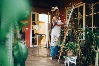 Woman standing by potted plant