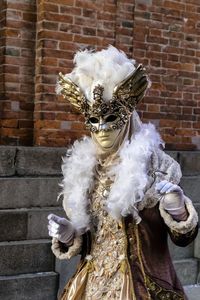 Full length of man wearing mask against brick wall