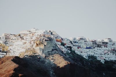 Buildings on mountain in town against clear sky