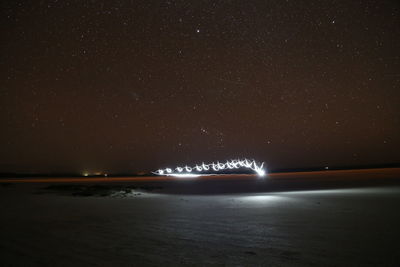 Scenic view of sea against star field at night