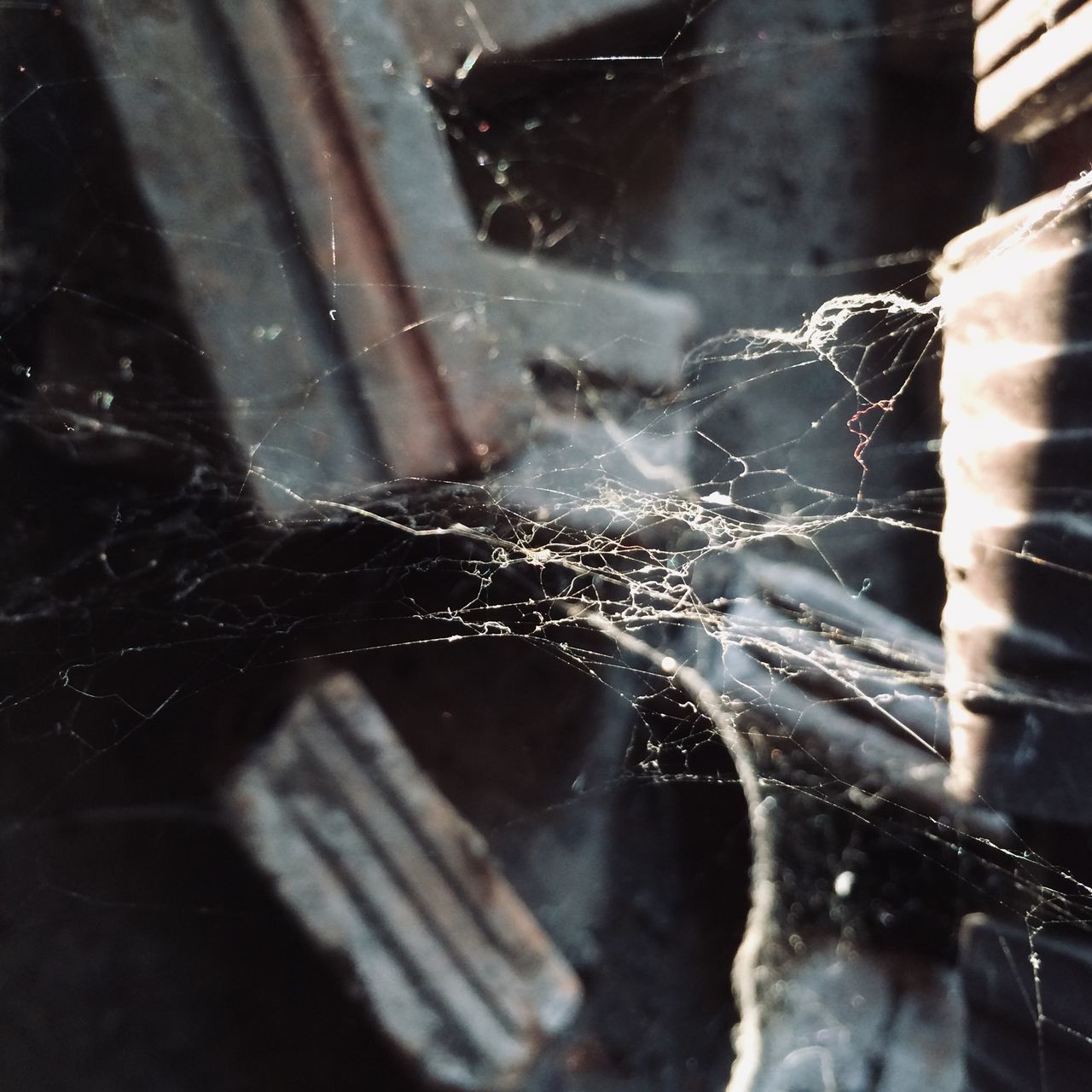 CLOSE-UP OF BROKEN GLASS WINDOW WITH SPIDER WEB