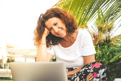 Smiling woman using laptop at outdoors