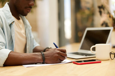 Midsection of businessman working at office