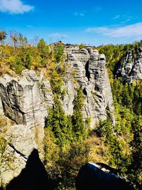 Scenic view of rock formation amidst trees against sky