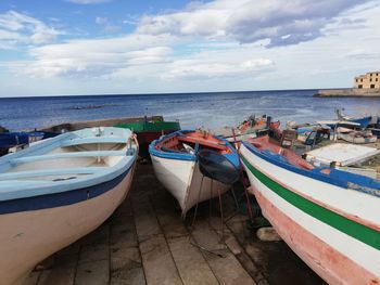 Boats moored in sea against sky