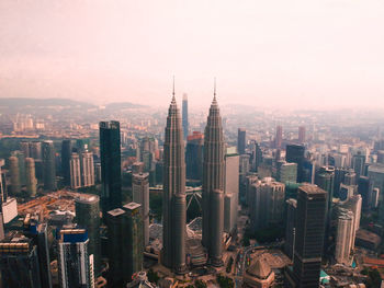 High angle view of petronas towers in city against sky