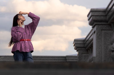 Full length of woman standing against sky