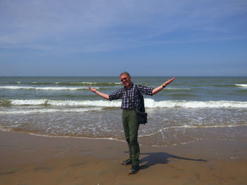 Full length of woman standing on beach against sky