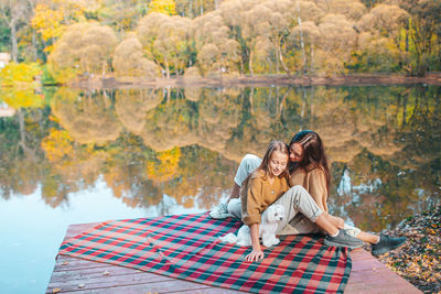 Family sitting by lake