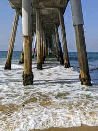 Wooden pier on sea against sky