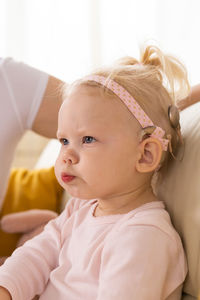 Portrait of cute baby boy looking away while lying on bed at home