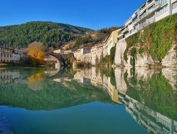 Scenic view of lake by buildings against clear sky