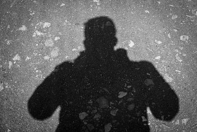 Shadow of man photographing on street