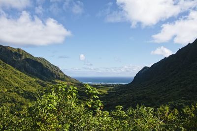 Scenic view of sea and mountains against sky