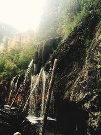 Scenic view of waterfall on sunny day