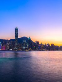 Illuminated buildings in city at sunset